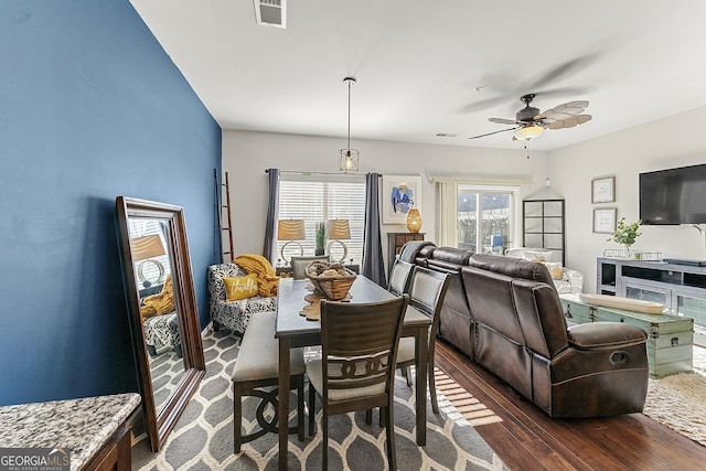 dining room with ceiling fan and dark wood-type flooring