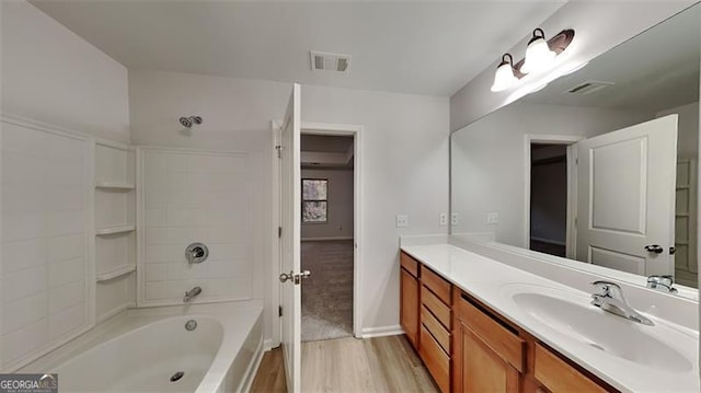 bathroom with vanity, hardwood / wood-style flooring, and shower / bathtub combination