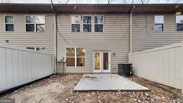 rear view of property with cooling unit and a patio