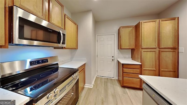 kitchen with appliances with stainless steel finishes and light hardwood / wood-style flooring