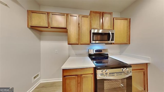 kitchen with light hardwood / wood-style floors and stainless steel appliances