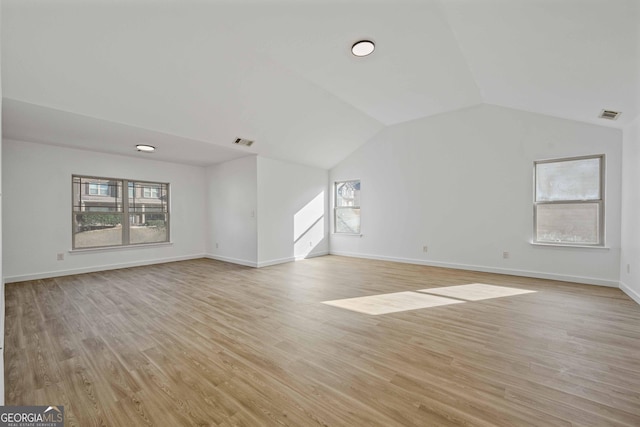 unfurnished living room with vaulted ceiling and light wood-type flooring