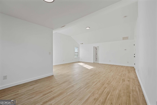 spare room with lofted ceiling and light hardwood / wood-style flooring