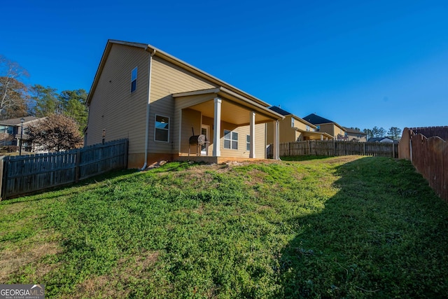 rear view of house featuring a lawn