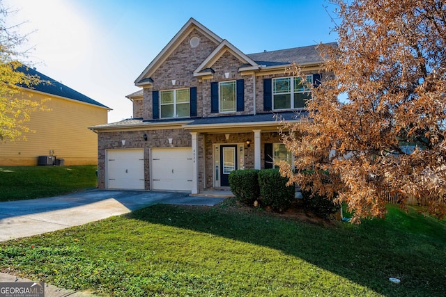 view of front of home featuring cooling unit, a garage, and a front yard