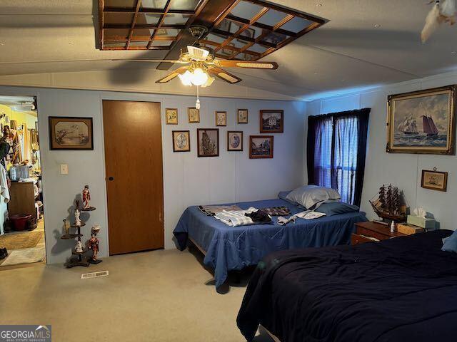 bedroom with ceiling fan, light colored carpet, and lofted ceiling