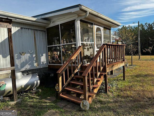 exterior space featuring a yard and a sunroom