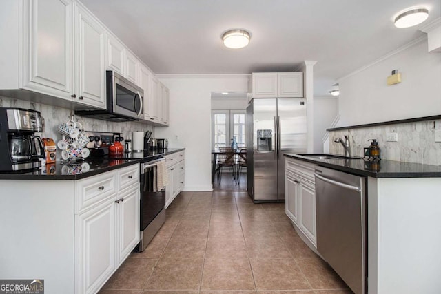 kitchen with sink, stainless steel appliances, tasteful backsplash, crown molding, and white cabinets