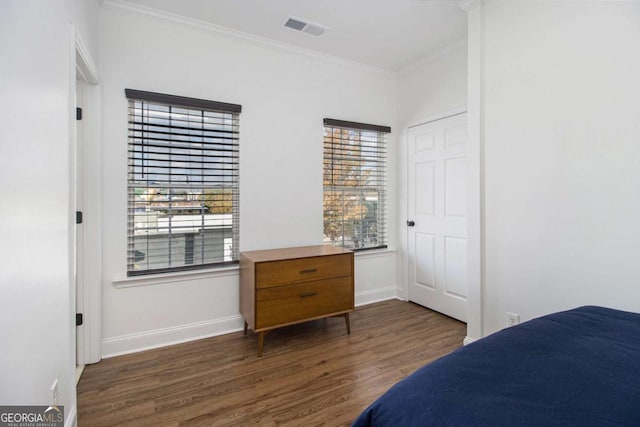 bedroom with multiple windows, crown molding, and dark wood-type flooring