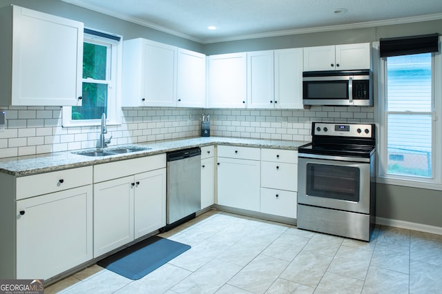 kitchen with white cabinets, appliances with stainless steel finishes, plenty of natural light, and sink