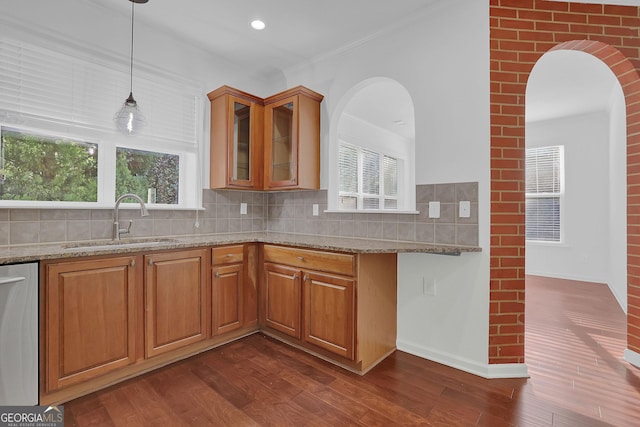 kitchen featuring a wealth of natural light, light stone counters, sink, and dark wood-type flooring