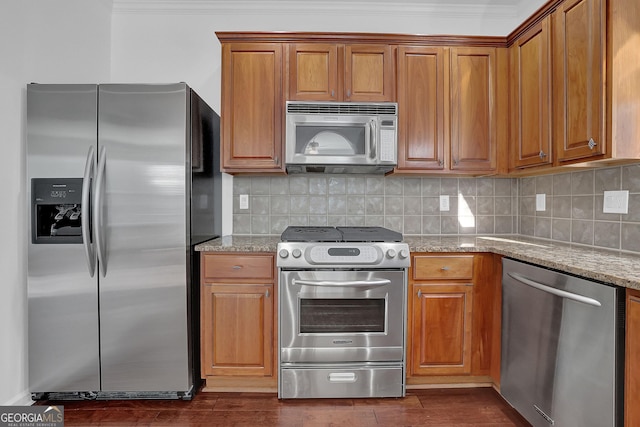 kitchen featuring decorative backsplash, light stone countertops, ornamental molding, and appliances with stainless steel finishes