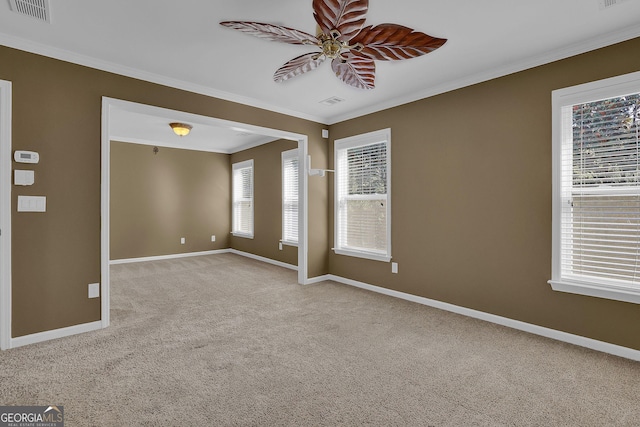 spare room featuring light colored carpet, ceiling fan, and crown molding