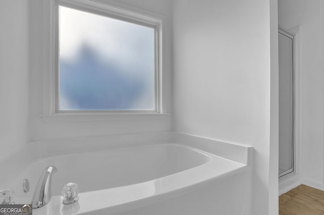 bathroom with tile patterned flooring and a tub