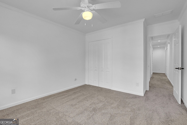 unfurnished bedroom featuring carpet, ceiling fan, ornamental molding, and a closet