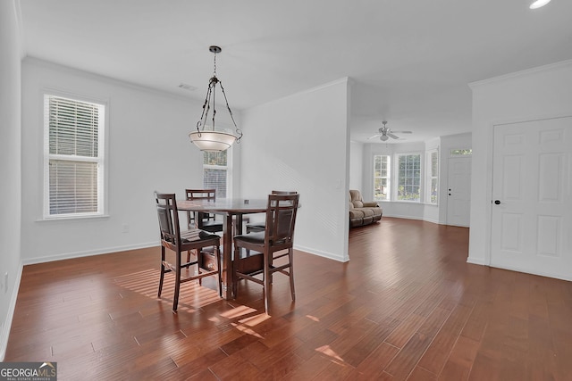 dining area featuring ceiling fan, dark wood-type flooring, and ornamental molding