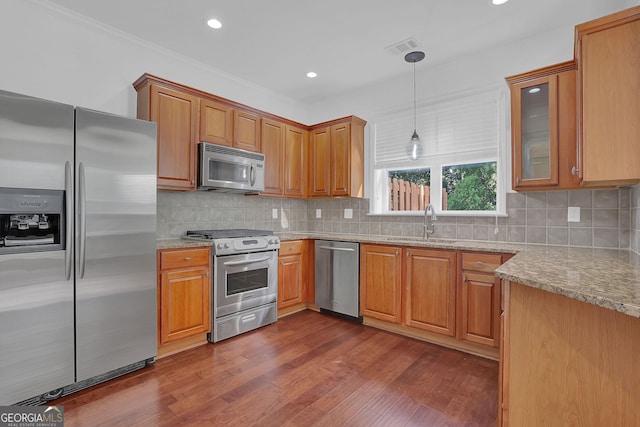 kitchen with backsplash, sink, dark wood-type flooring, and appliances with stainless steel finishes