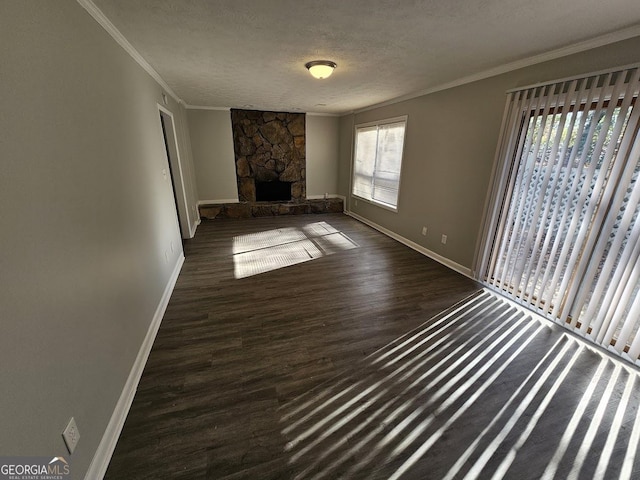 unfurnished living room with a fireplace, a textured ceiling, dark hardwood / wood-style flooring, and ornamental molding