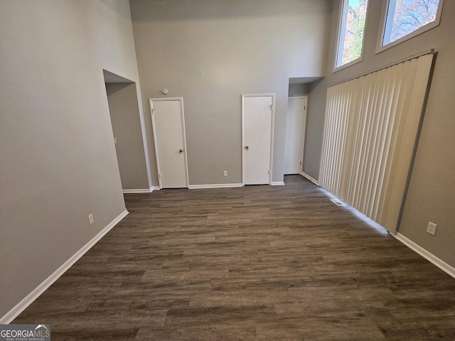 interior space with dark hardwood / wood-style floors and a high ceiling