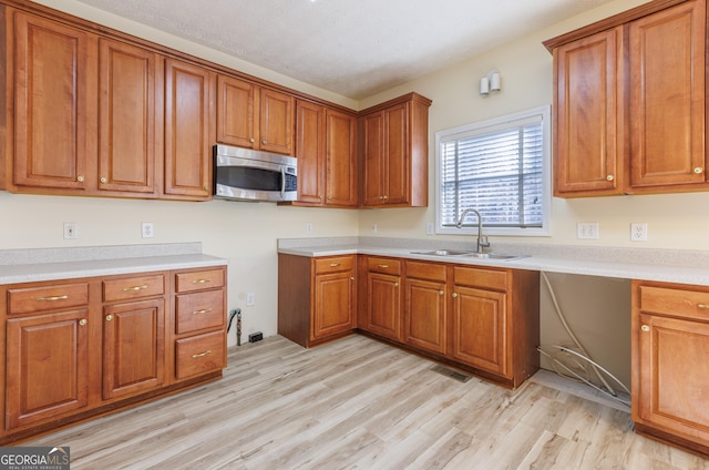 kitchen with sink and light hardwood / wood-style flooring