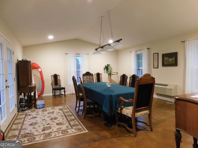 dining area featuring an AC wall unit, french doors, and lofted ceiling