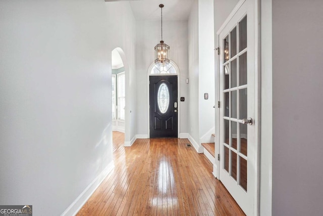 entryway with wood-type flooring and a high ceiling