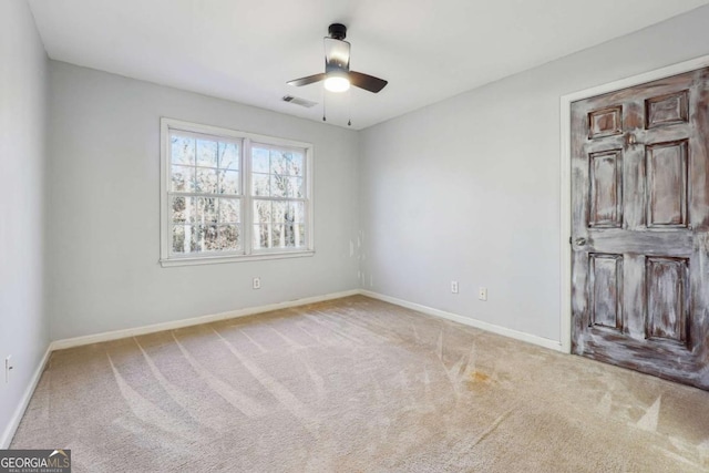 empty room with ceiling fan and light colored carpet