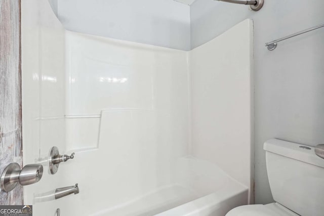 bathroom featuring toilet and bathing tub / shower combination