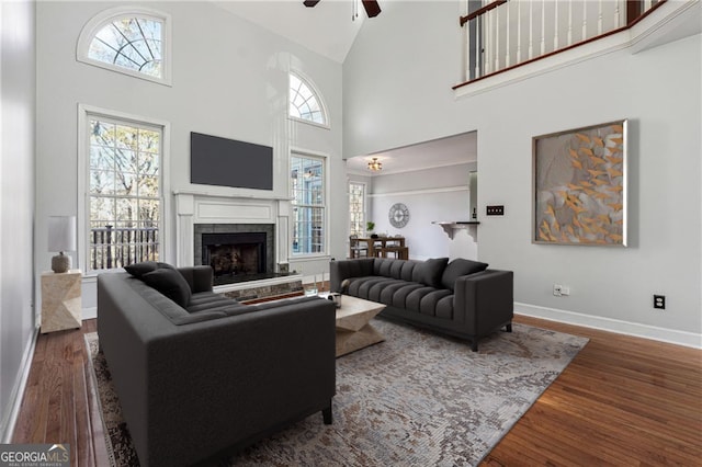 living room with a fireplace, dark hardwood / wood-style flooring, high vaulted ceiling, and ceiling fan