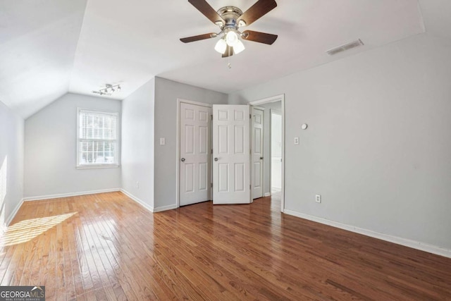 unfurnished bedroom with a closet, hardwood / wood-style flooring, ceiling fan, and lofted ceiling