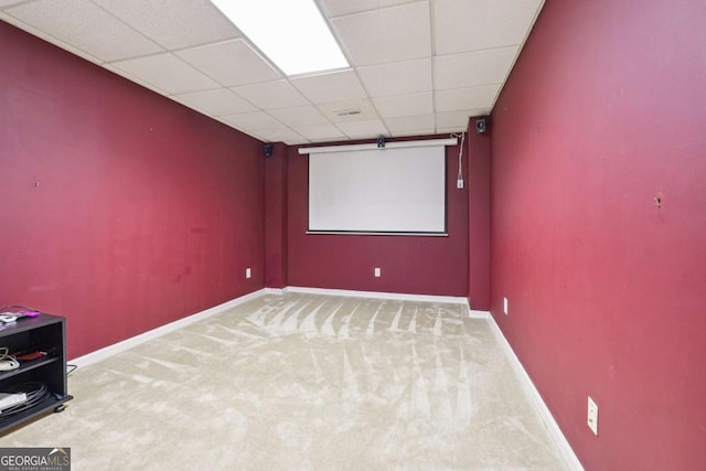 carpeted home theater with a drop ceiling