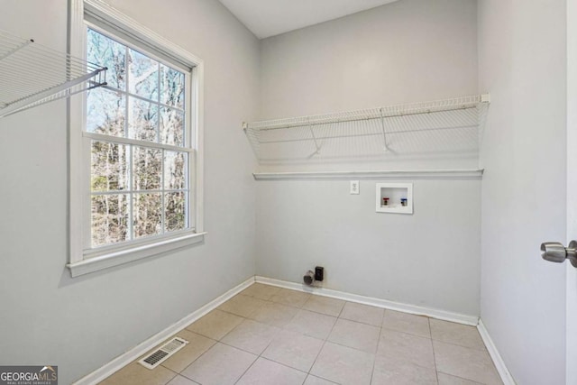 clothes washing area featuring hookup for a washing machine and light tile patterned floors