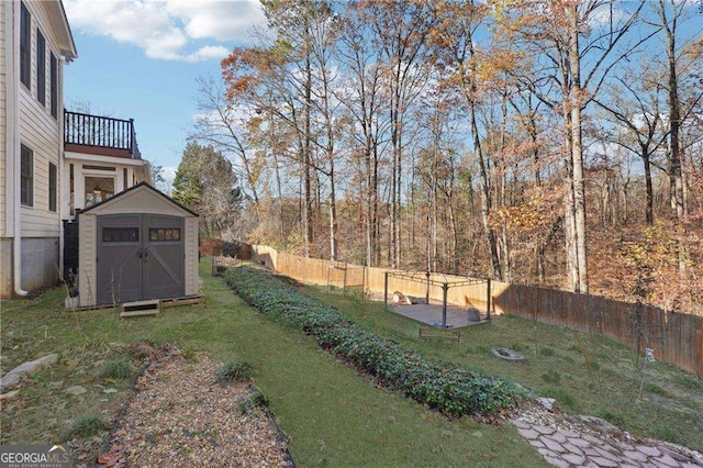 view of yard featuring a balcony and a storage unit