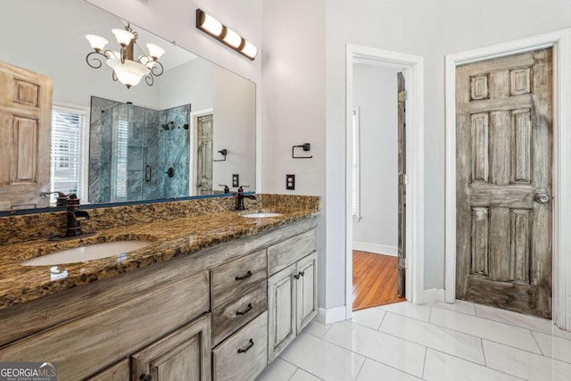 bathroom featuring vanity, wood-type flooring, a shower with door, and a chandelier