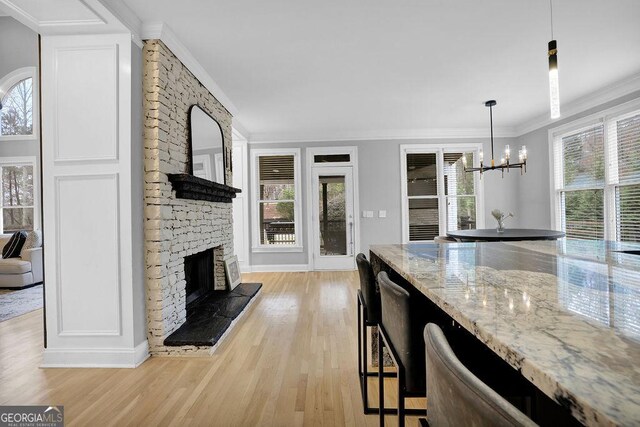 kitchen featuring a healthy amount of sunlight, hanging light fixtures, and light hardwood / wood-style floors