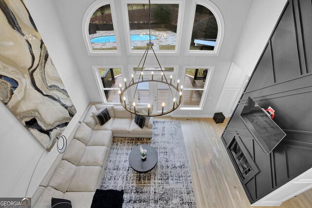 living room with light hardwood / wood-style floors, a wealth of natural light, and a notable chandelier