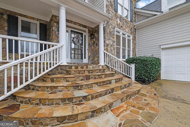 view of exterior entry with covered porch and a garage