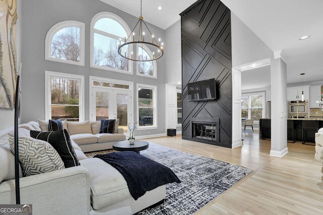 living room with a towering ceiling, light hardwood / wood-style flooring, and a wealth of natural light