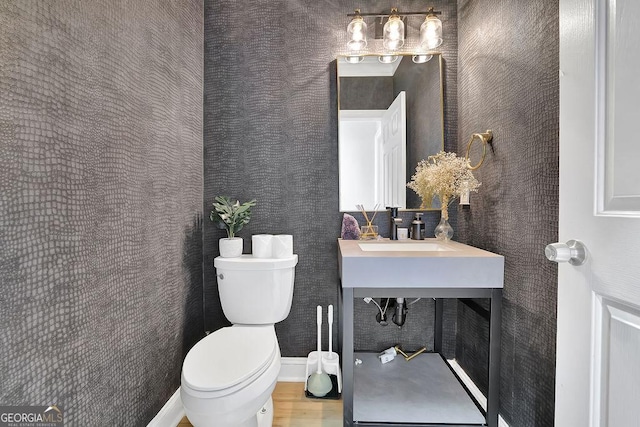 bathroom featuring sink, hardwood / wood-style floors, and toilet