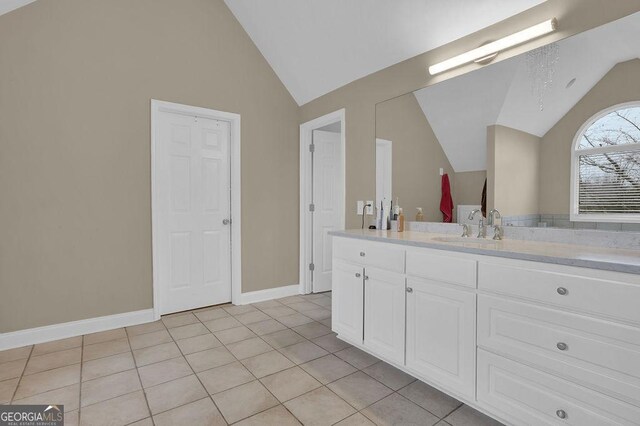 bathroom featuring tile patterned floors, vanity, and vaulted ceiling