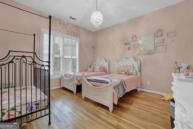 bedroom with light wood-type flooring and a chandelier