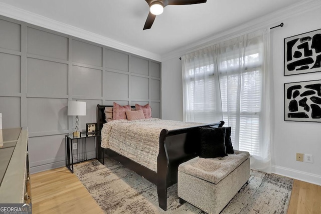 bedroom featuring light wood-type flooring, ceiling fan, and crown molding