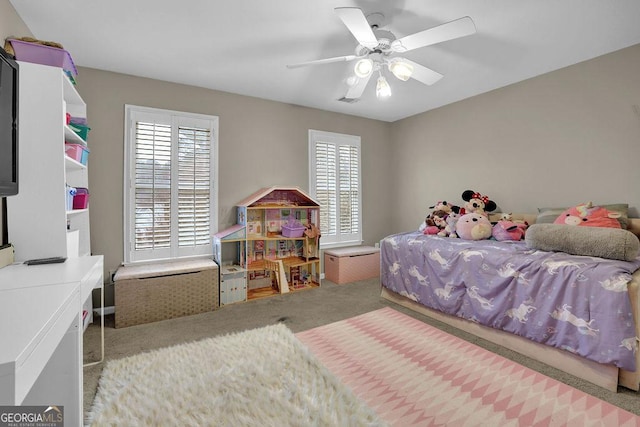 bedroom featuring multiple windows, ceiling fan, and carpet