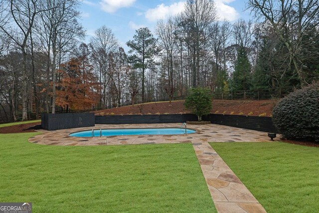 view of pool featuring a yard and a patio