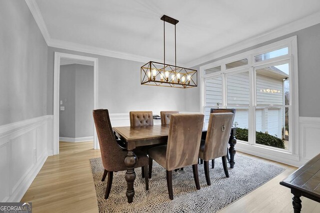 dining space with light hardwood / wood-style floors and crown molding