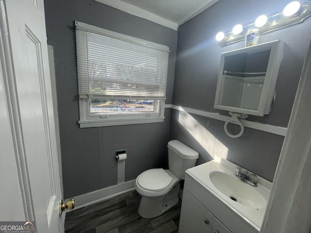 bathroom featuring wood-type flooring, vanity, toilet, and tile walls