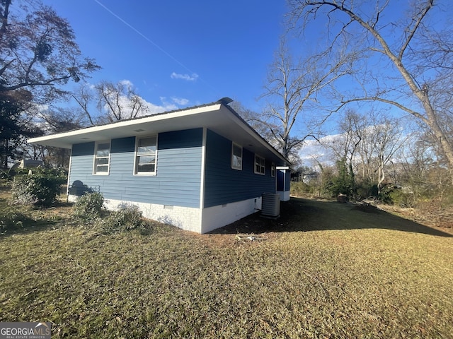 view of side of property featuring a yard and central AC unit