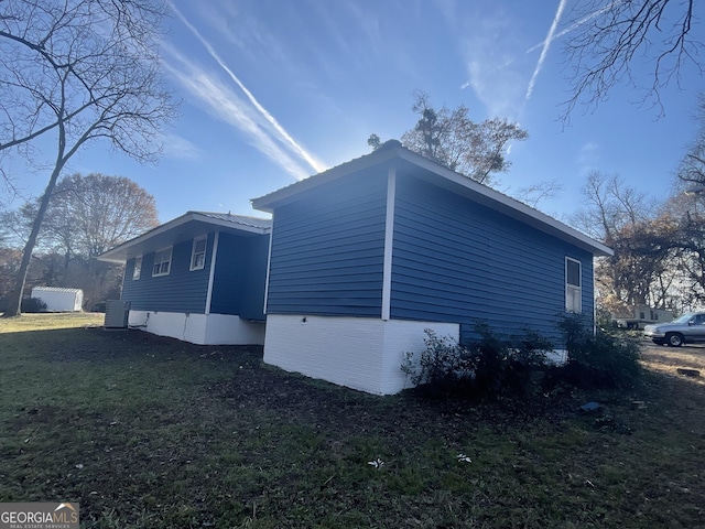 view of home's exterior with a lawn and central AC