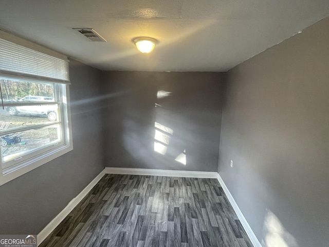 spare room with dark wood-type flooring