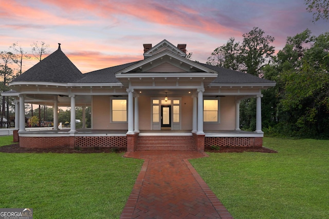 view of front of house featuring covered porch and a yard